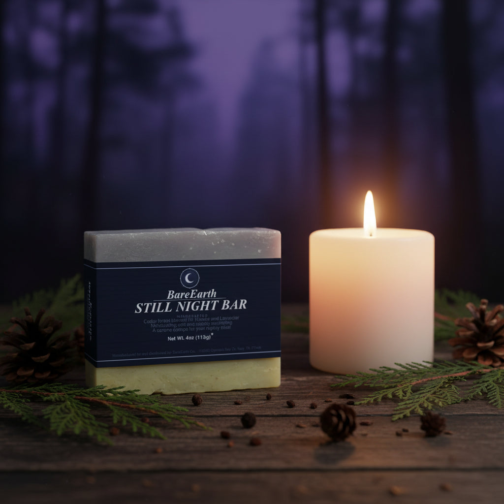 Still Night cedar and lavender soap bar with lit candle, cedar branches, pinecones in misty forest