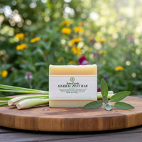 Herbal Zest soap bar with fresh lemongrass and sage on wooden cutting board, garden background