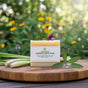 Herbal Zest soap bar with fresh lemongrass and sage on wooden cutting board, garden background